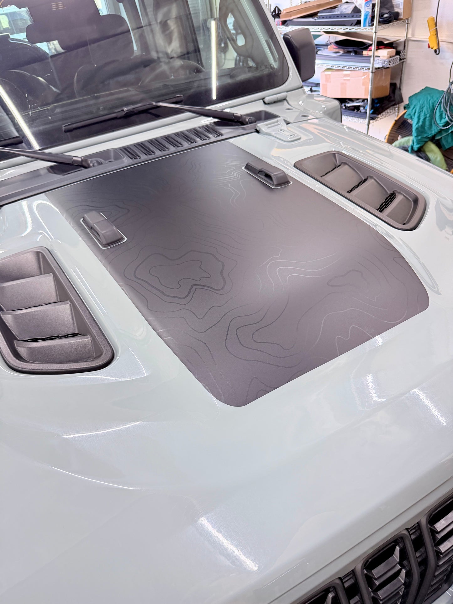 Topo vinyl hood wrap installed on Jeep for reduced glare and rugged off-road styling