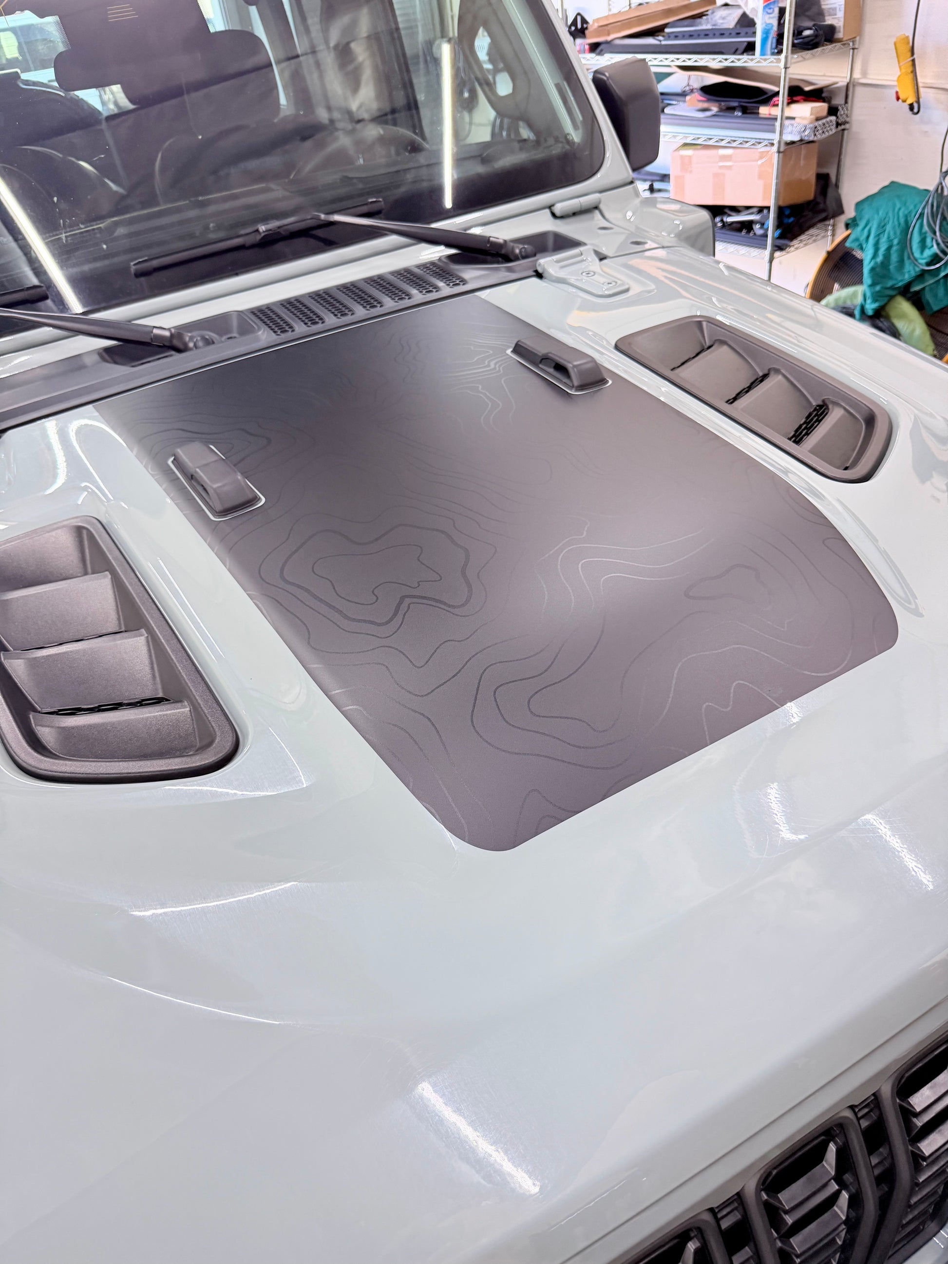 Topo vinyl hood wrap installed on Jeep for reduced glare and rugged off-road styling