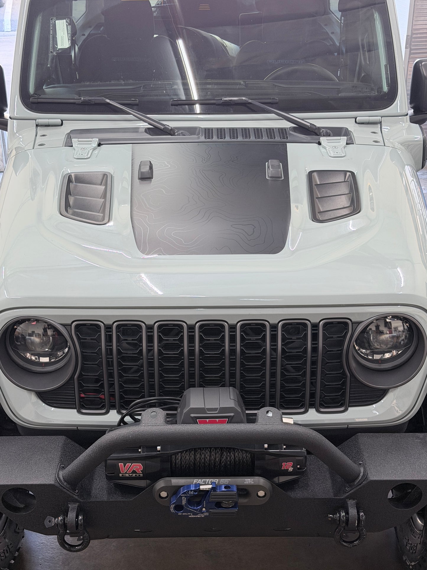 Topographic hood wrap with matte black terrain pattern installed on Jeep Rubicon by Beyond Wraps